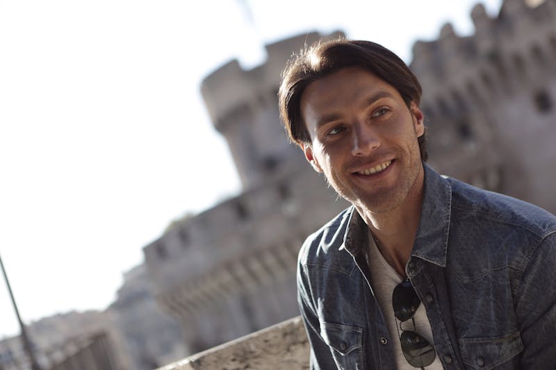 Punch pizza chef crafting pizza at wood-fired oven